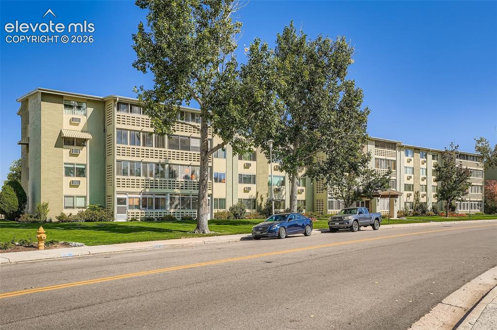 Image 12 of 27: Multi-story residential building featuring a light green exterior, multiple