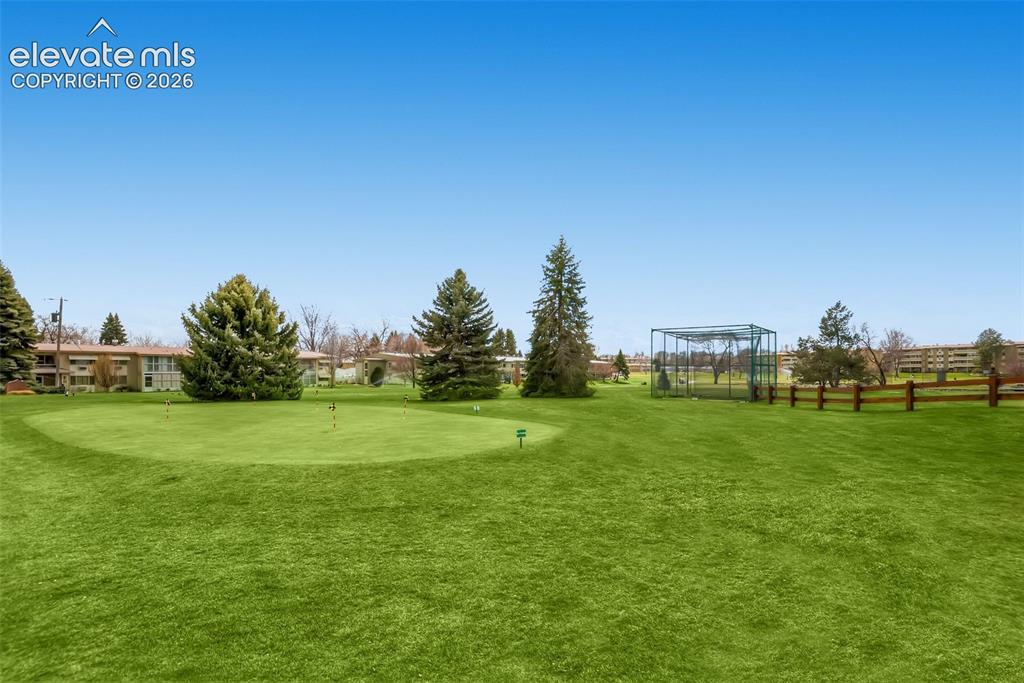 Image 14 of 27: Expansive grounds featuring a manicured lawn with mature evergreen and deci