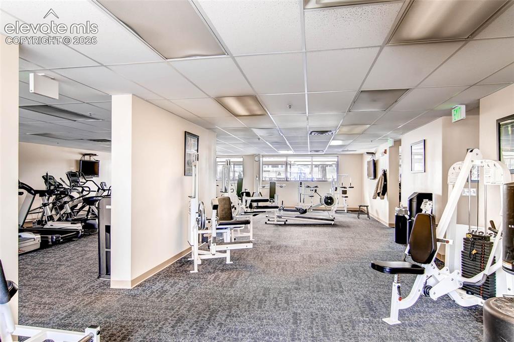 Image 16 of 27: Spacious fitness center featuring a variety of exercise equipment, carpeted