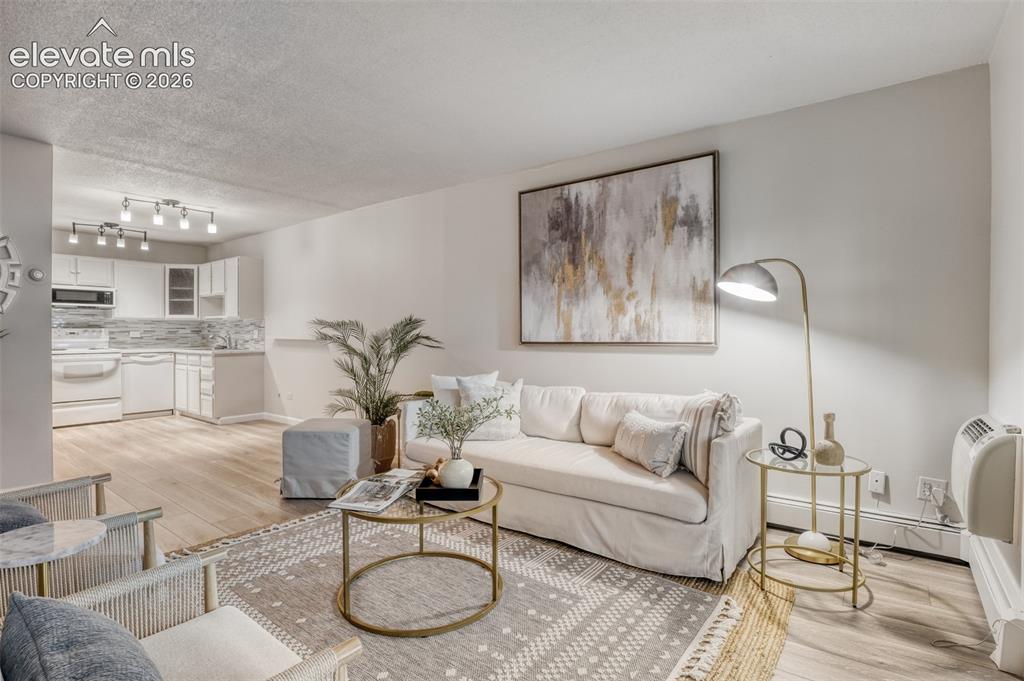 Image 2 of 27: Open-concept living space featuring wood-finish flooring, white walls, and 