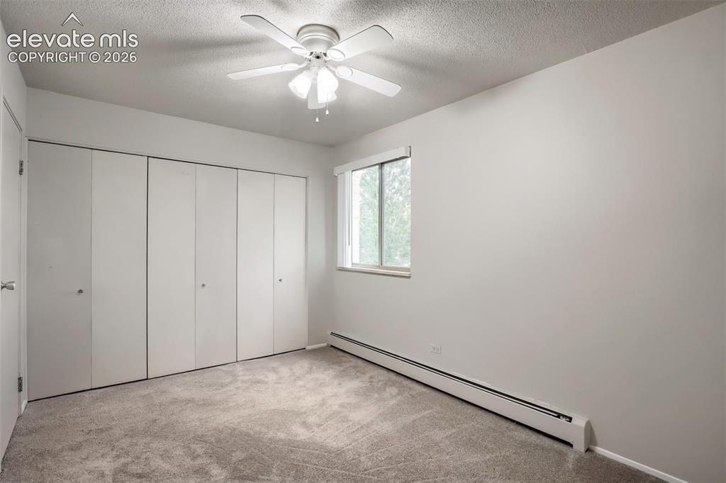 Image 8 of 27: Bedroom featuring a ceiling fan, light gray wall paint, and gray carpet flo