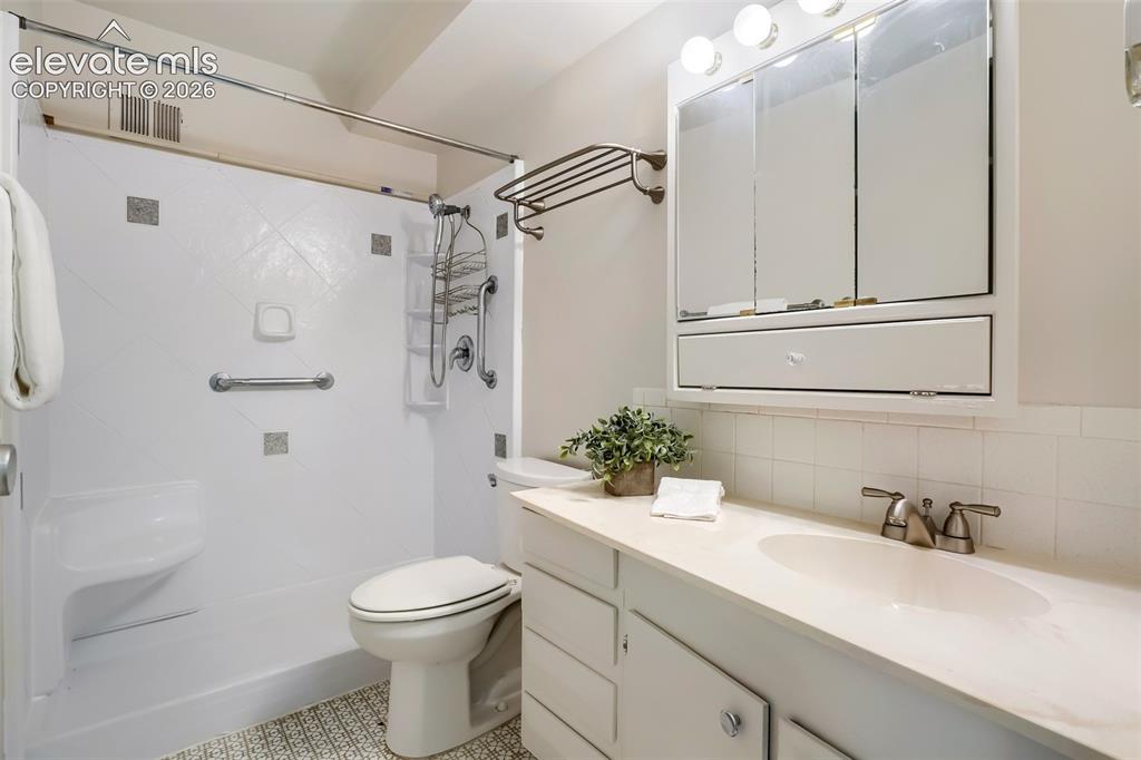 Image 9 of 27: Bathroom featuring a white vanity with an integrated sink, brushed nickel f