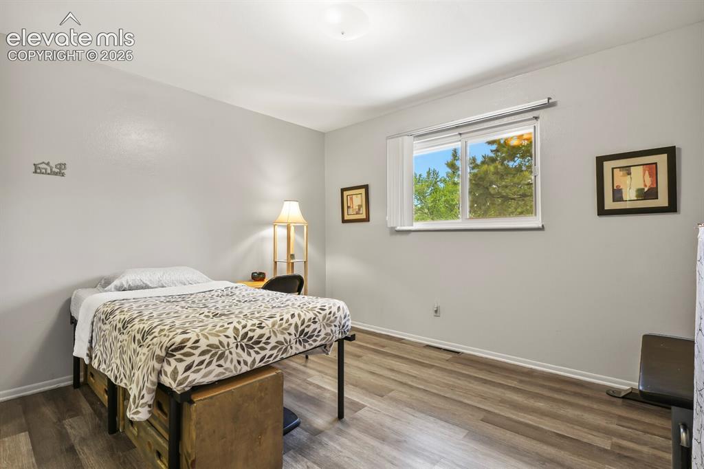 Image 10 of 31: Room featuring wood-finish flooring, light grey painted walls, and white tr