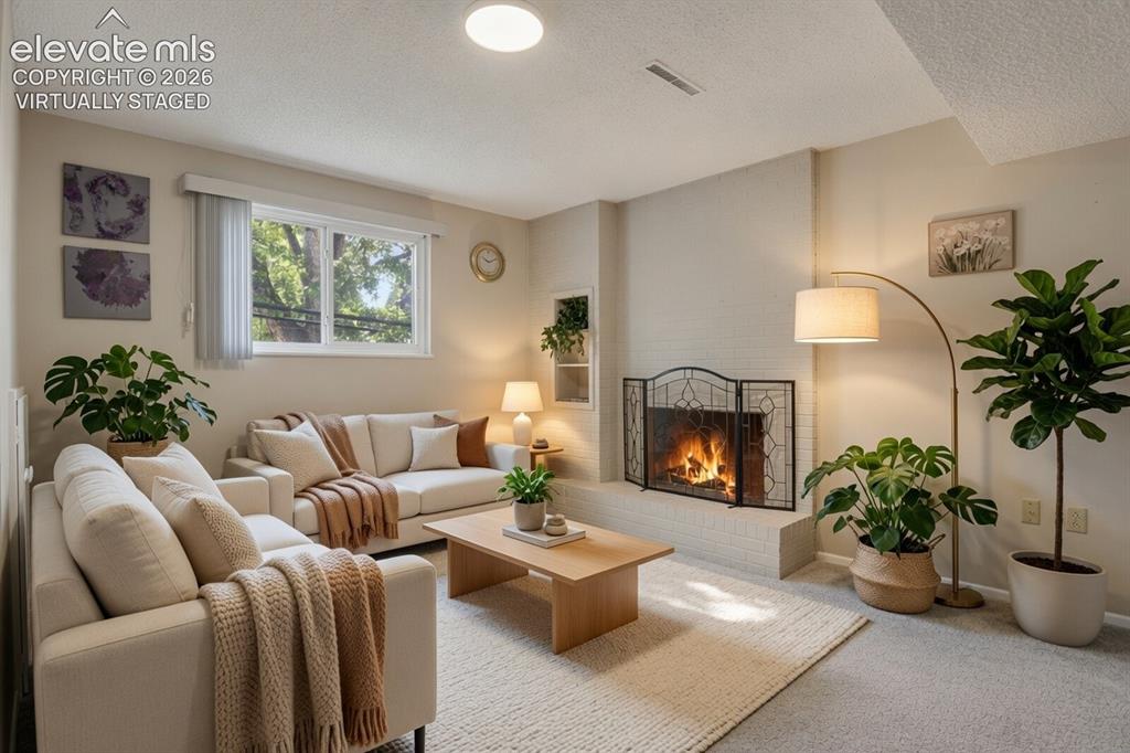 Image 11 of 31: Virtually staged living room with a wood-burning fireplace with decorative