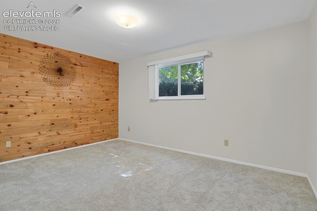 Image 14 of 31: Virtually Staged Bedroom Serene primary bedroom showcasing a wood-accent ac
