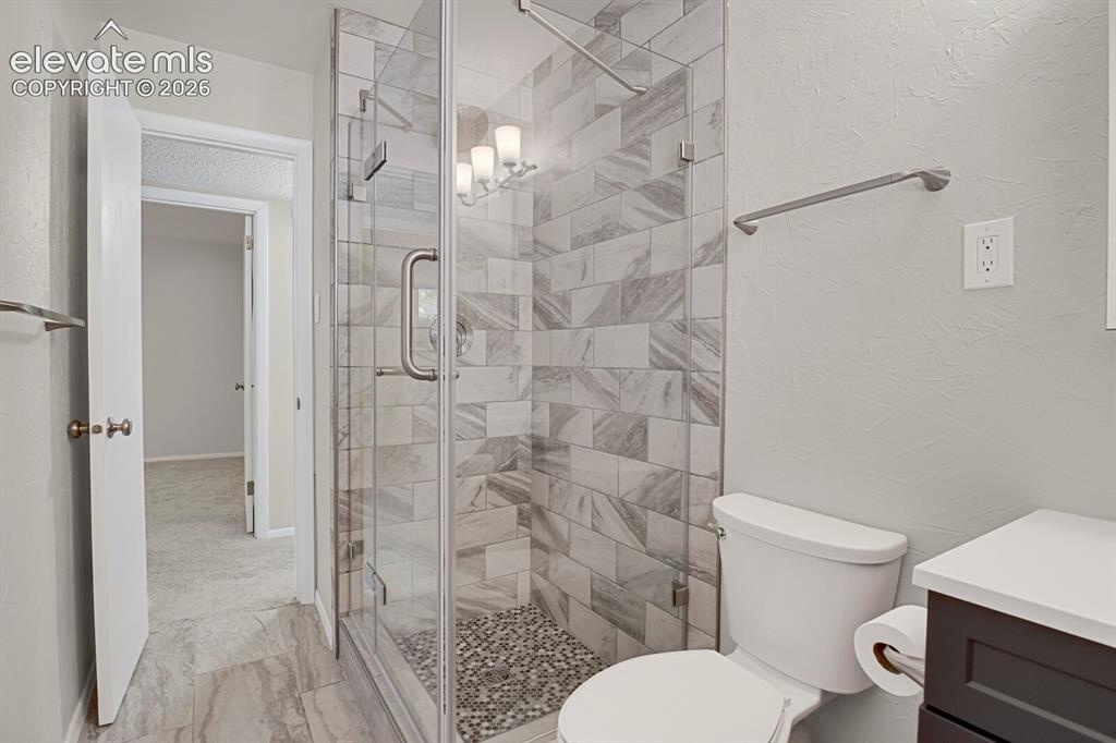 Image 15 of 31: Spa-inspired primary bathroom featuring a frameless glass walk-in shower wi