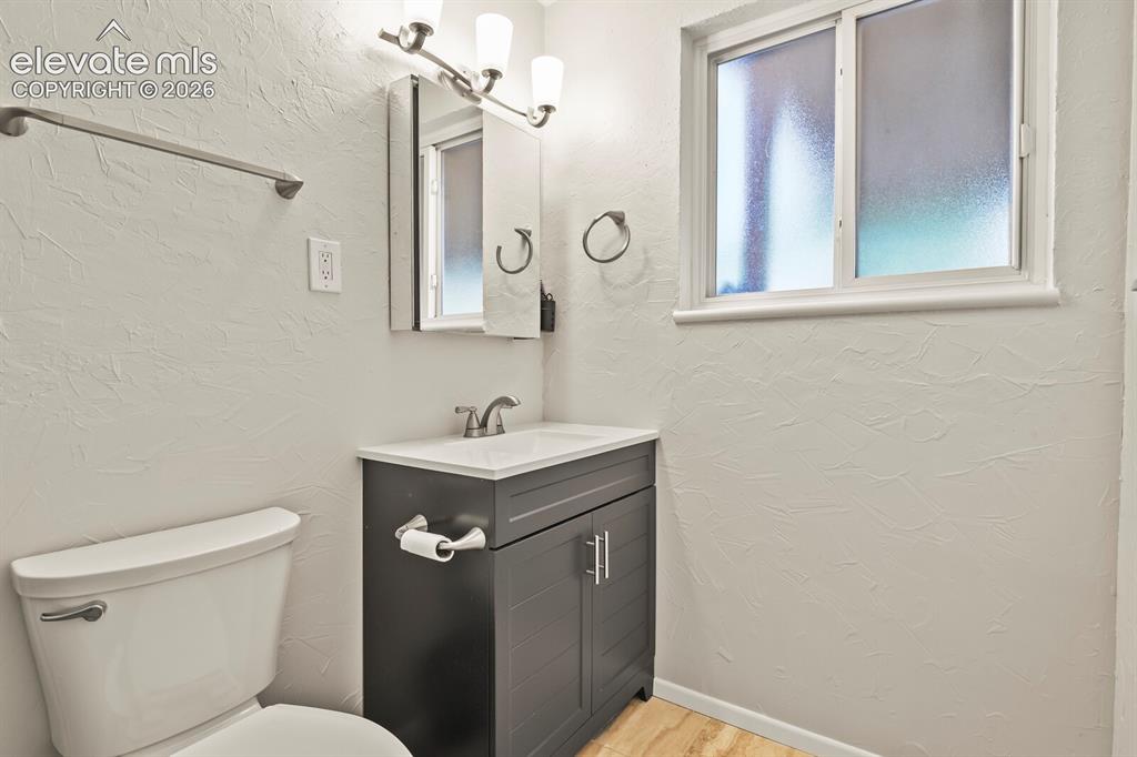 Image 16 of 31: Bathroom featuring a gray vanity with an integrated sink, brushed nickel fa