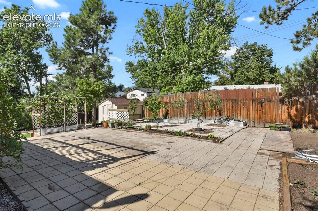 Image 19 of 31: Expansive patio featuring large-format pavers with geometric layout, border