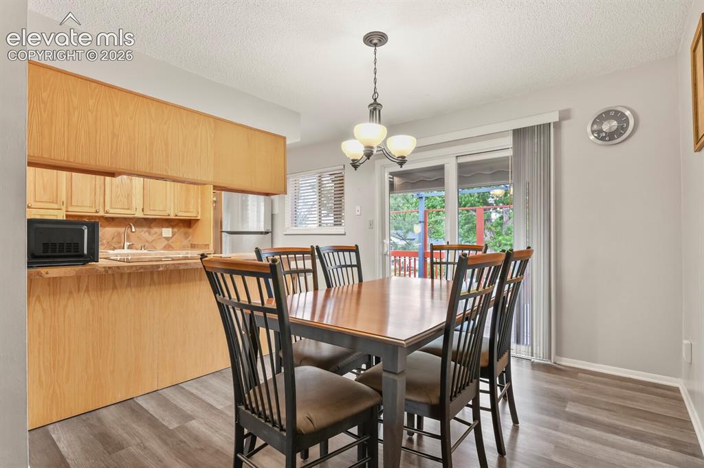 Image 21 of 31: Dining area featuring wood-finish flooring, a contemporary ceiling light fi
