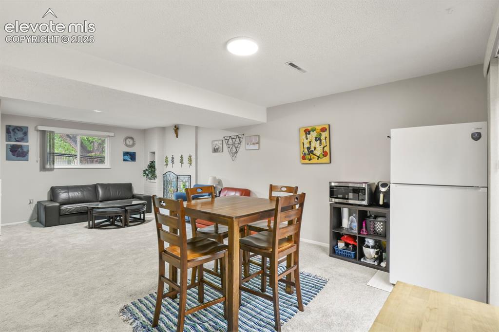Image 31 of 39: Carpeted living area featuring a window, recessed lighting, and a dining sp