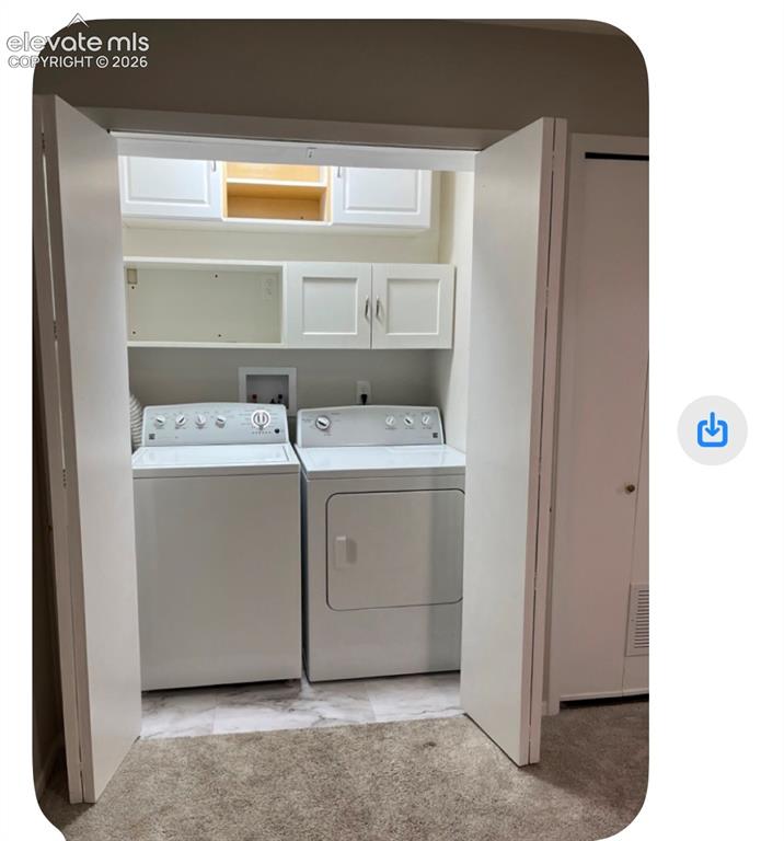 Image 31 of 31: Dedicated laundry area with built-in cabinetry, shelving, and a washer and