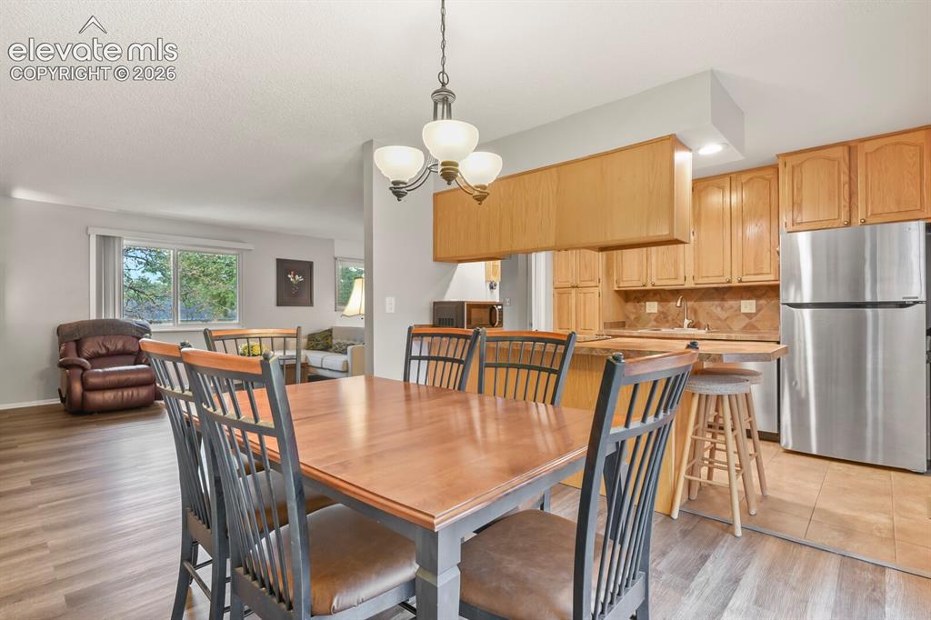 Image 5 of 31: Dining area featuring a chandelier, wood-finish flooring, and light gray wa
