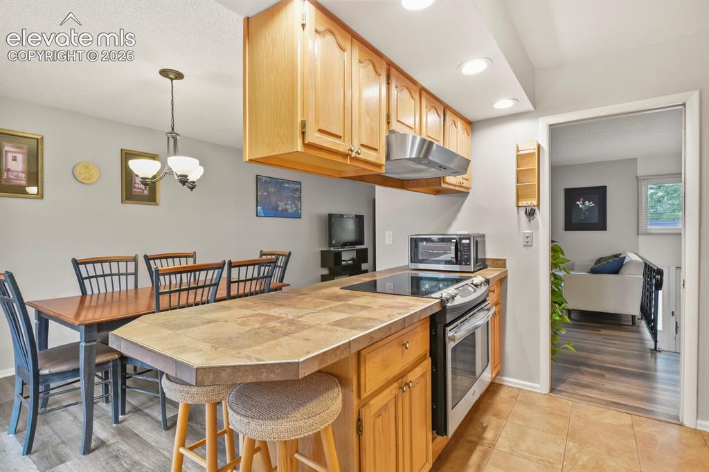 Image 6 of 31: Kitchen featuring wood-finish cabinetry, stainless steel appliances, and a