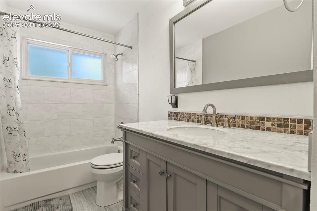Image 9 of 31: Bathroom featuring a white bathtub with subway tile surround, and a frosted