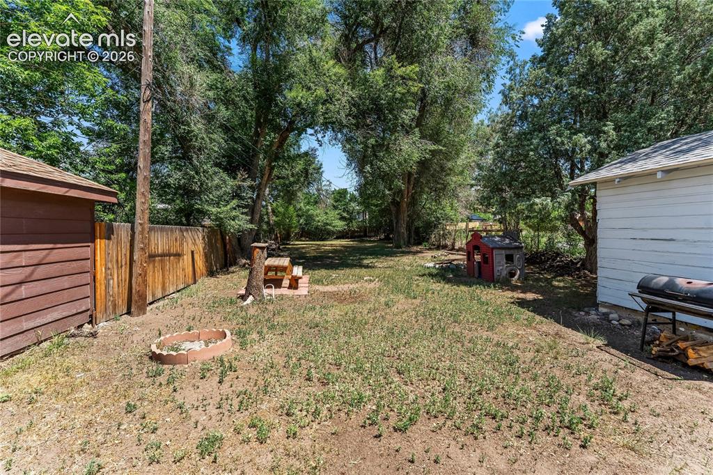 Image 24 of 34: Backyard with mature trees