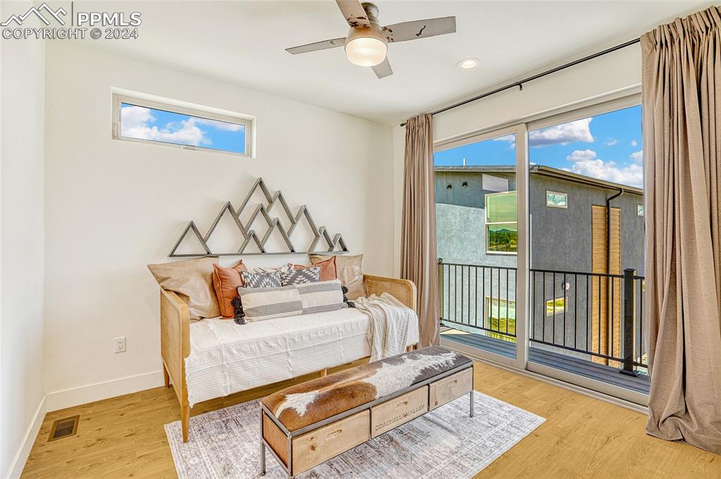 Image 10 of 24: Bedroom with access to outside, multiple windows, and light hardwood / wood