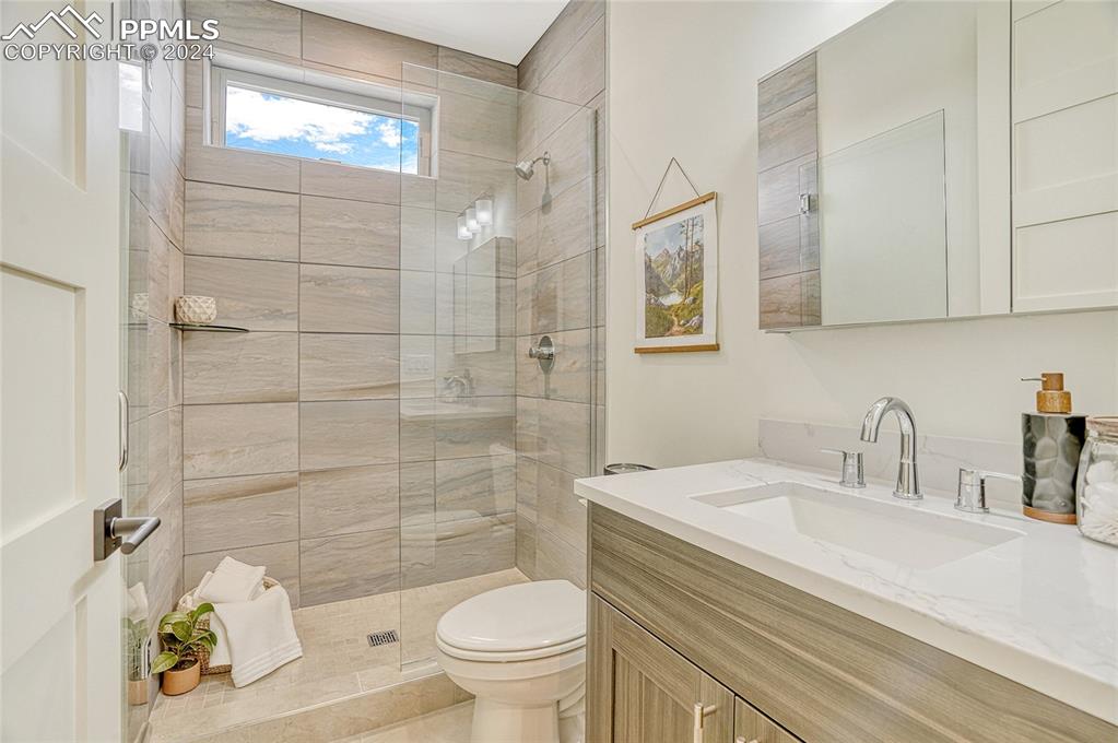 Image 14 of 24: Bathroom featuring vanity, toilet, and walk in shower