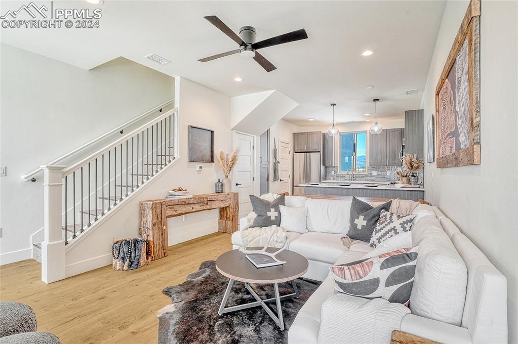 Image 4 of 24: Living room featuring ceiling fan, sink, and light wood-type flooring