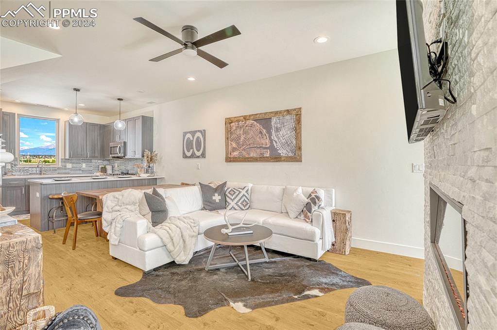 Image 5 of 24: Living room with ceiling fan, light wood-type flooring, and a fireplace