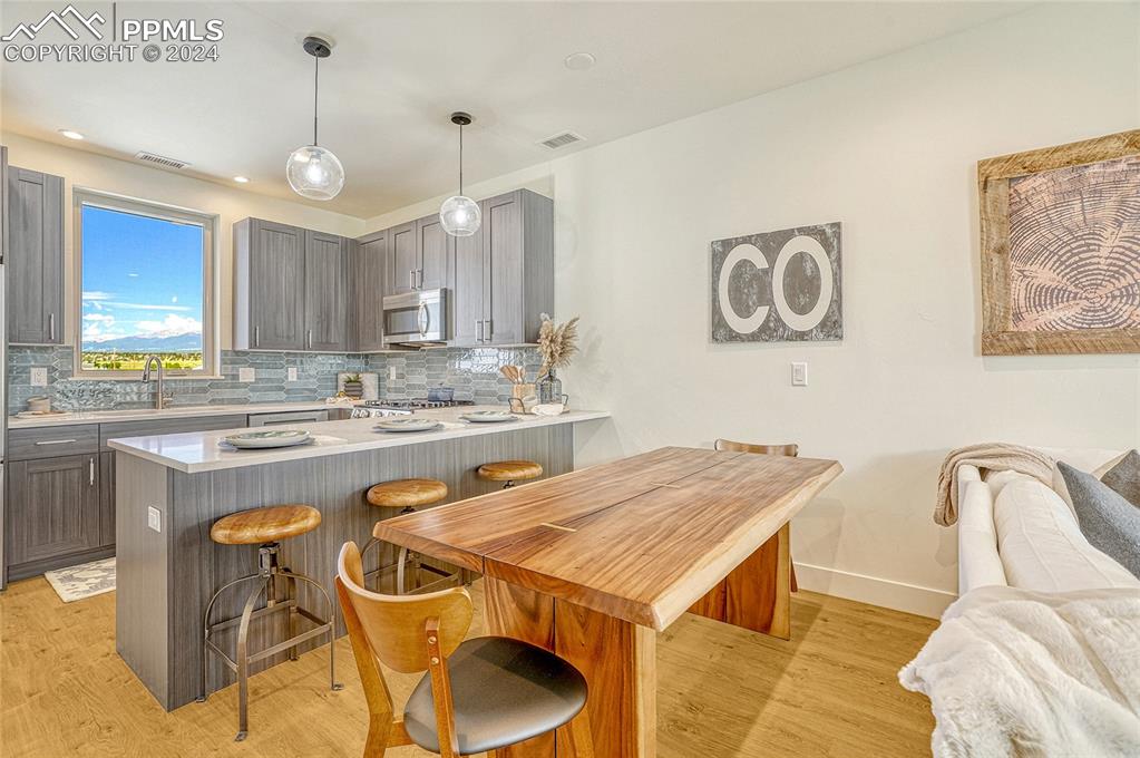 Image 8 of 24: Kitchen featuring sink, hanging light fixtures, light hardwood / wood-style