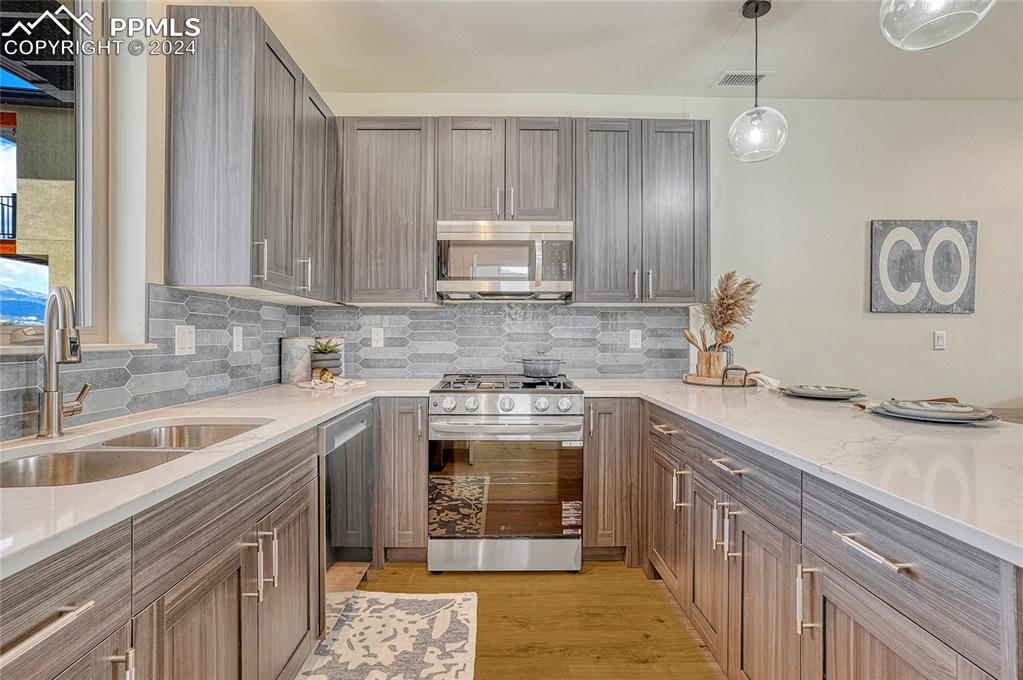 Image 9 of 24: Kitchen featuring sink, light stone countertops, light wood-type flooring, 