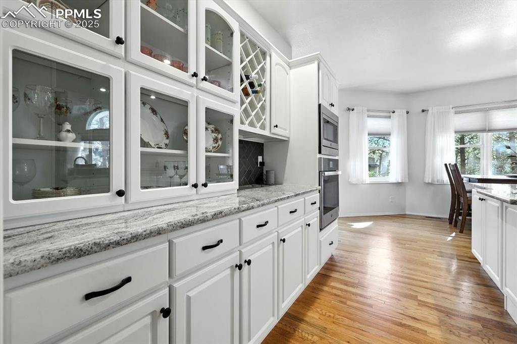 Image 15 of 45: Kitchen with appliances with stainless steel finishes, glass insert cabinet