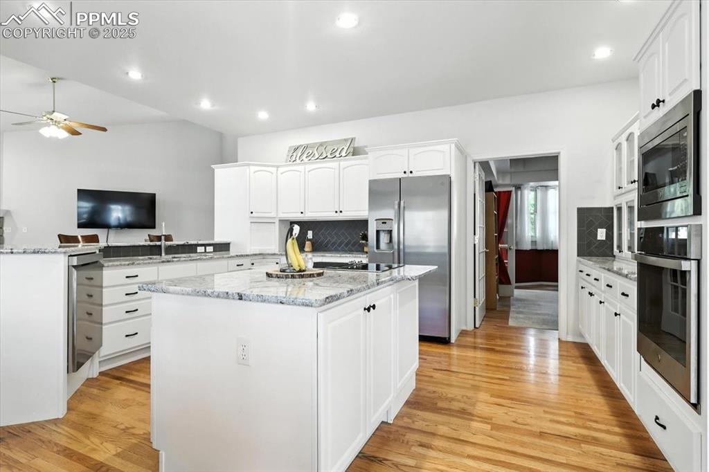 Image 17 of 45: Kitchen with appliances with stainless steel finishes, a center island, cei