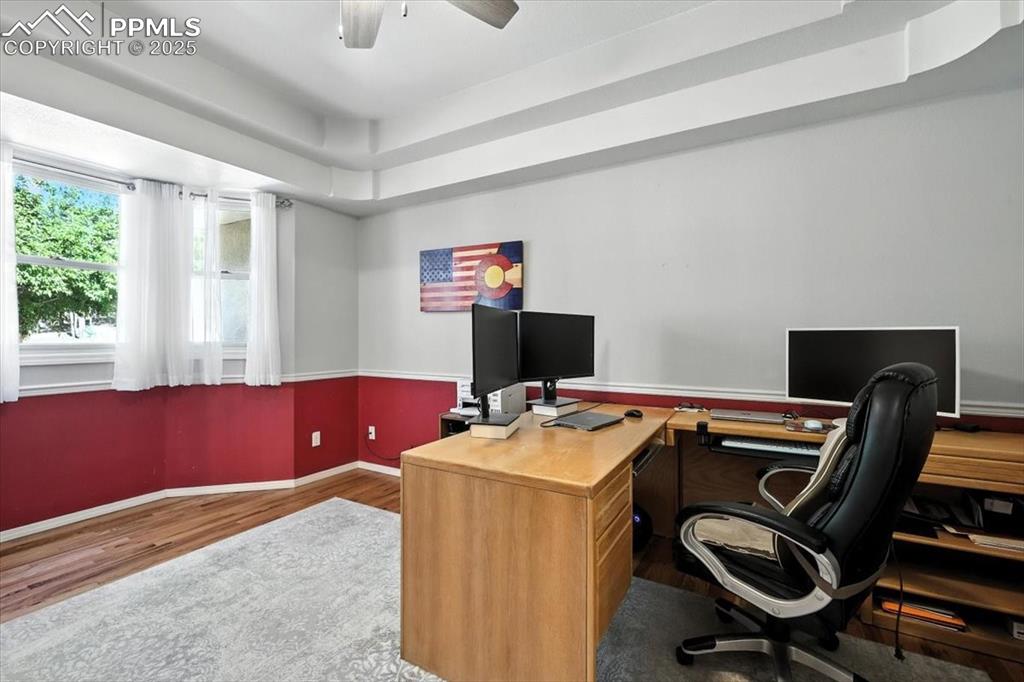 Image 24 of 45: Office space featuring wood finished floors and ceiling fan