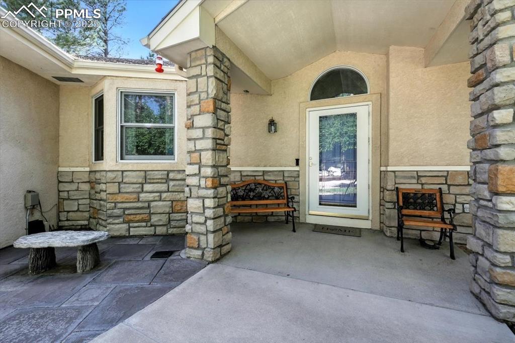 Image 4 of 45: Property entrance with stone siding and stucco siding