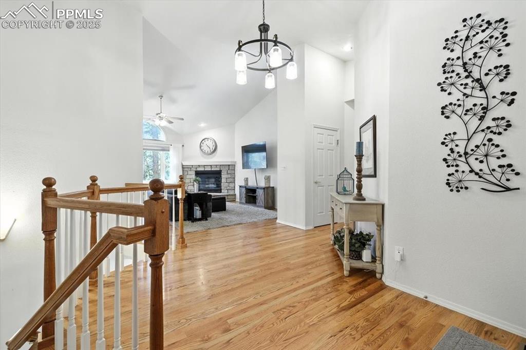 Image 8 of 45: Hall with high vaulted ceiling, light wood-style floors, and a chandelier