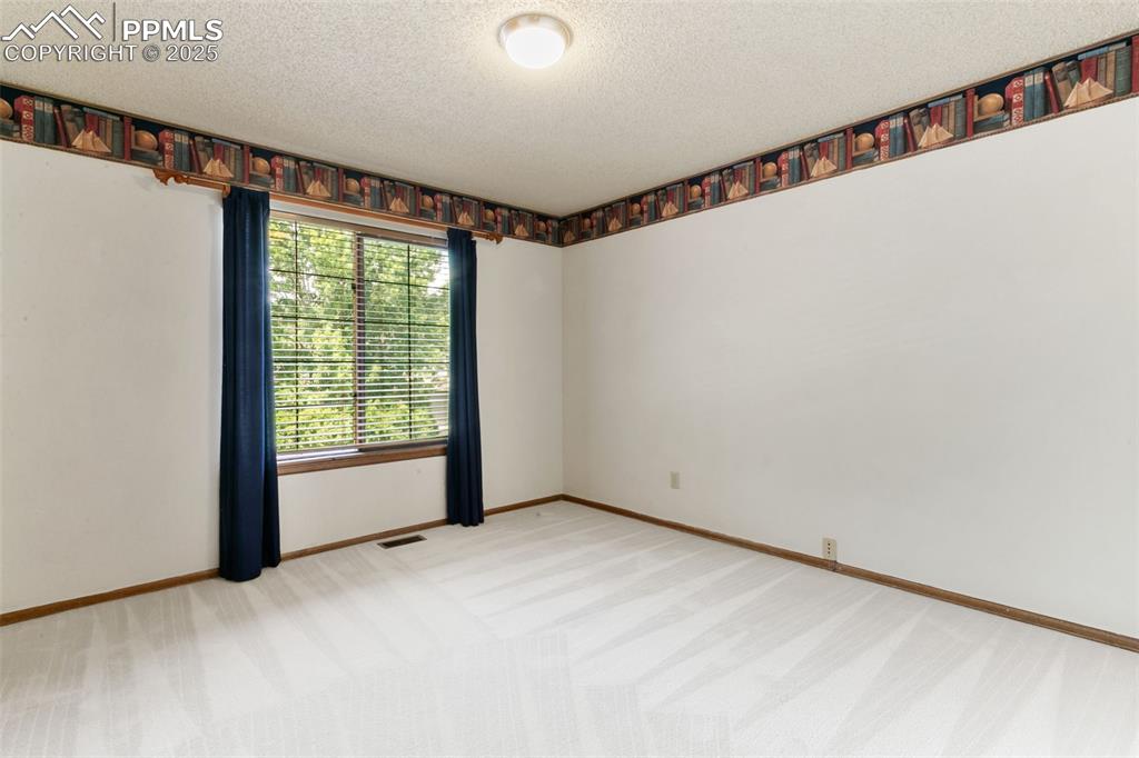 Image 20 of 30: Unfurnished room featuring light carpet and a textured ceiling