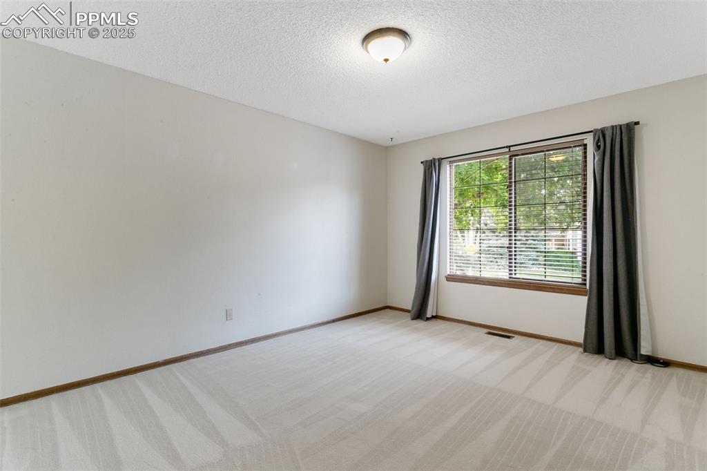 Image 22 of 30: Spare room with light carpet and a textured ceiling