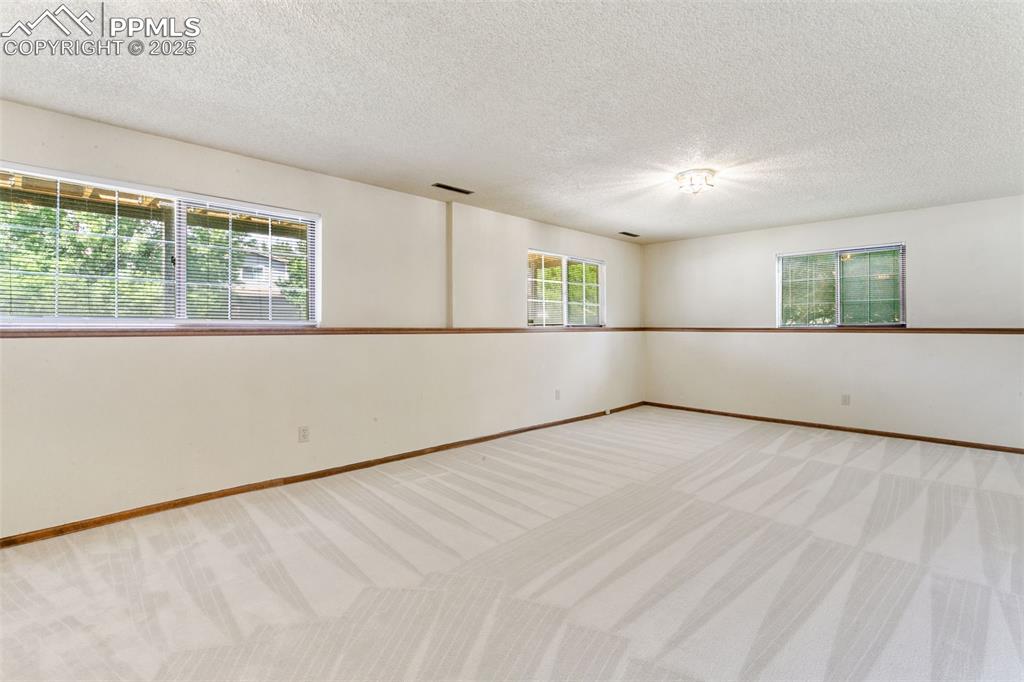 Image 23 of 30: Unfurnished room featuring carpet floors, healthy amount of natural light,