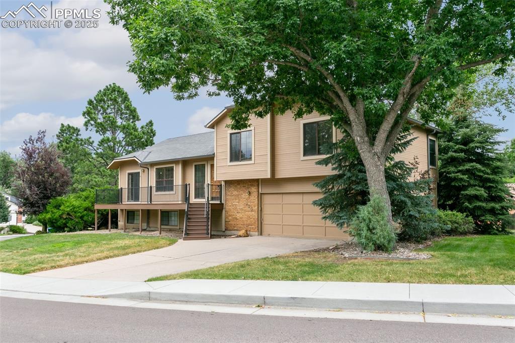 Image 3 of 30: View of front facade featuring stairway, driveway, an attached garage, a fr