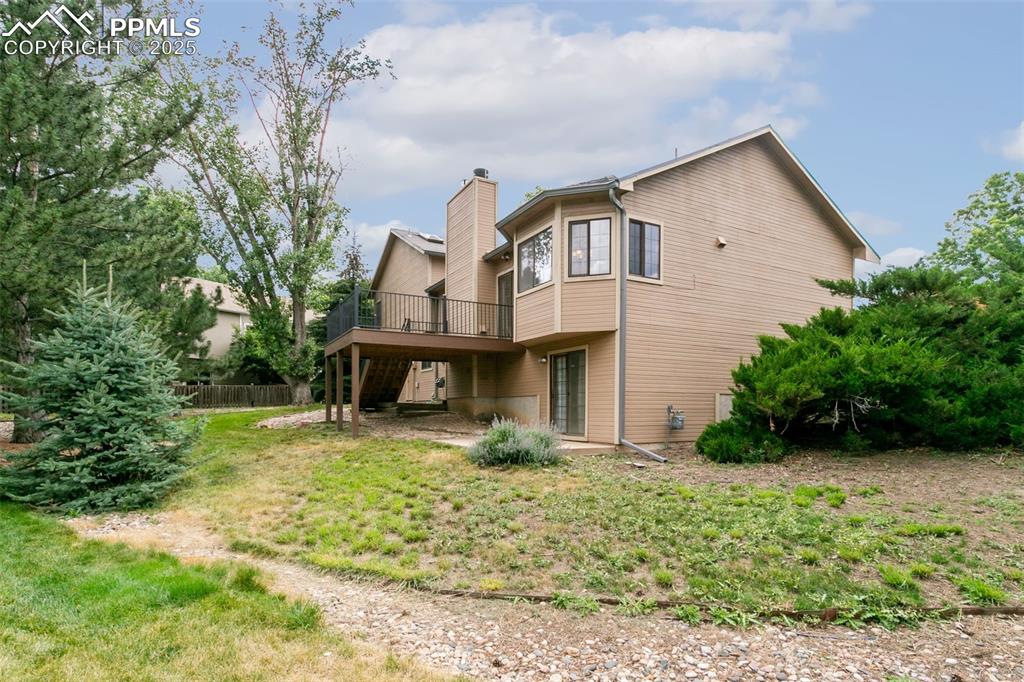 Image 30 of 30: Rear view of property featuring a wooden deck and a chimney