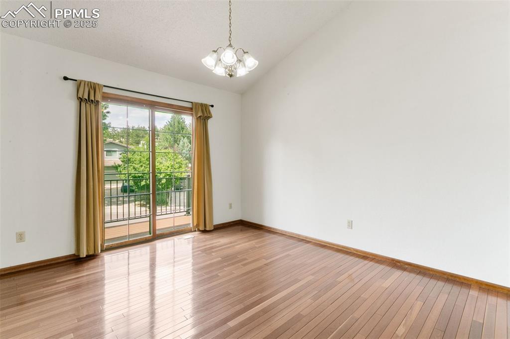 Image 9 of 30: Spare room with a chandelier, light wood-style floors, and lofted ceiling