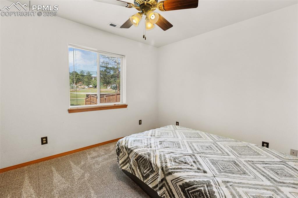 Image 12 of 30: Carpeted bedroom featuring ceiling fan.