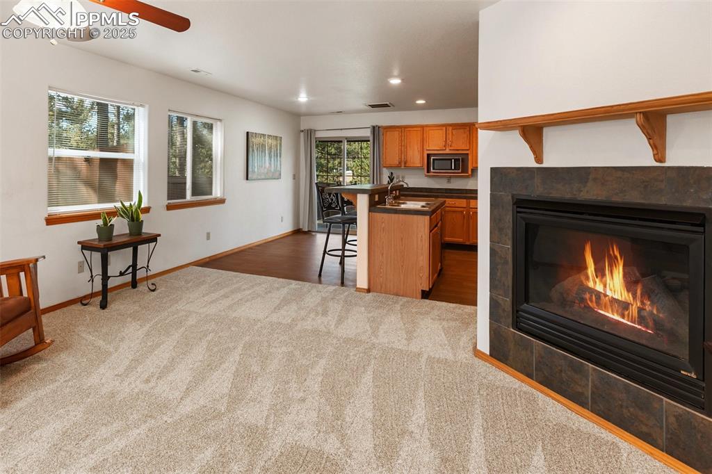 Image 4 of 30: Welcoming living room with cozy carpet and fireplace. 