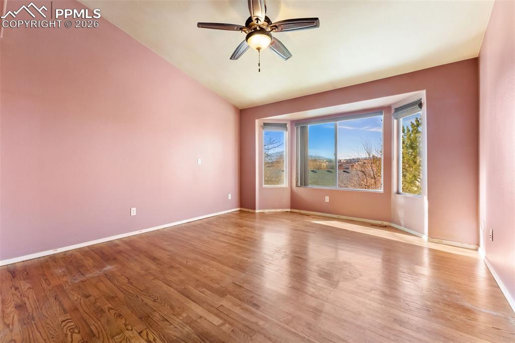 Image 12 of 34: Unfurnished room with a ceiling fan, light wood finished floors, and lofted
