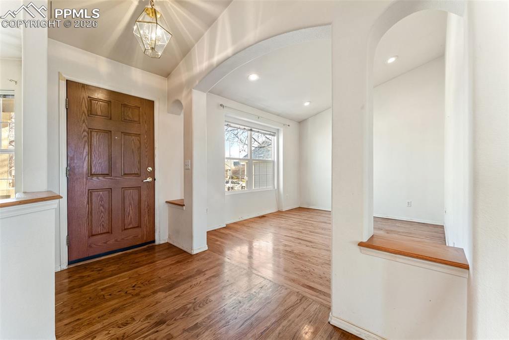 Image 2 of 34: Foyer with arched walkways, recessed lighting, wood finished floors, and a 