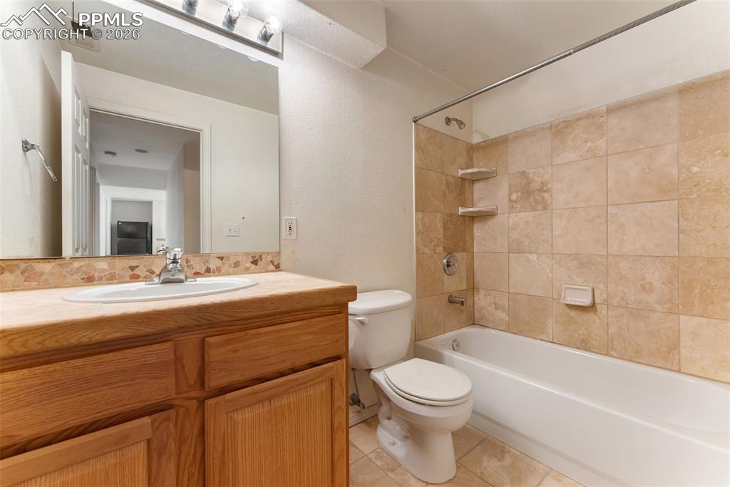 Image 9 of 34: Full bathroom featuring  shower combination, vanity, and light tile pattern