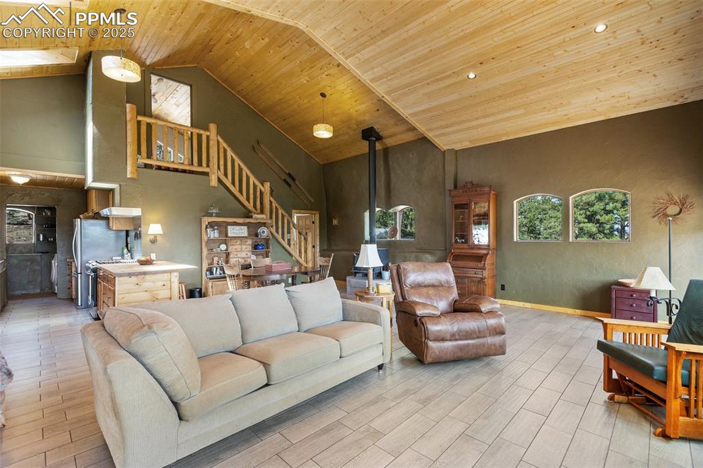 Image 12 of 50: High ceilings and golden light from the tongue and groove ceilings fill thi