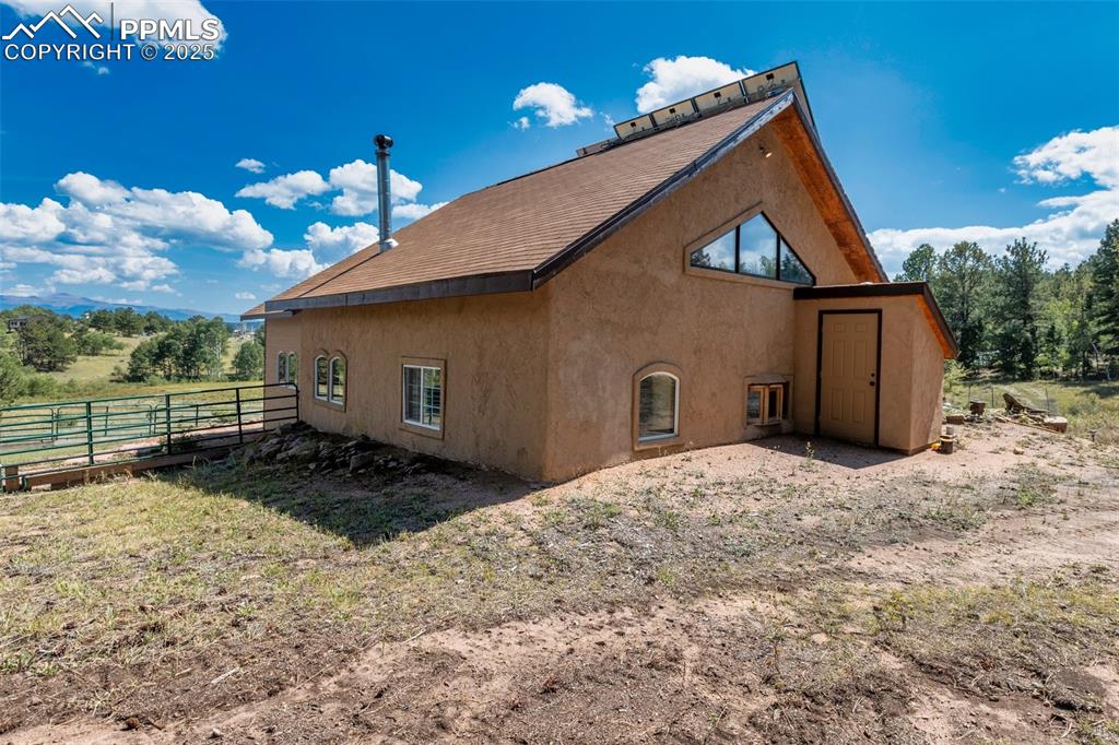 Image 2 of 50: Stucco and wood sided straw bale home. and custom 18" walls on 10 acres bor