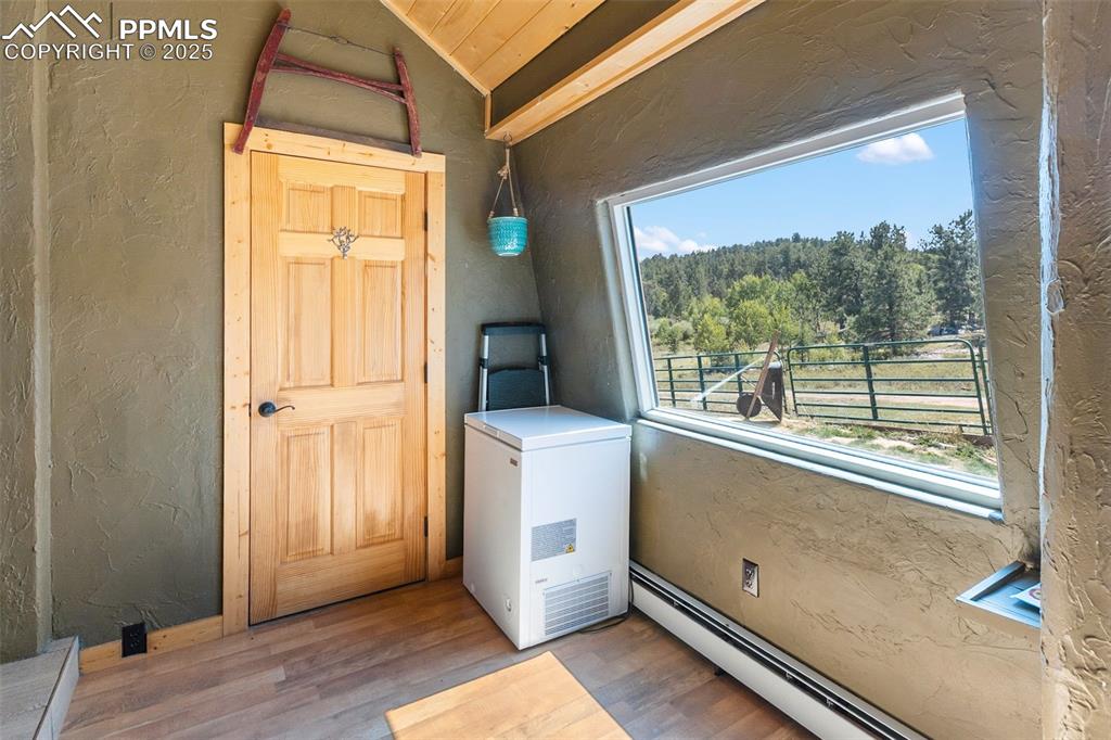 Image 23 of 50: Sunroom off the kitchen with guest bath.