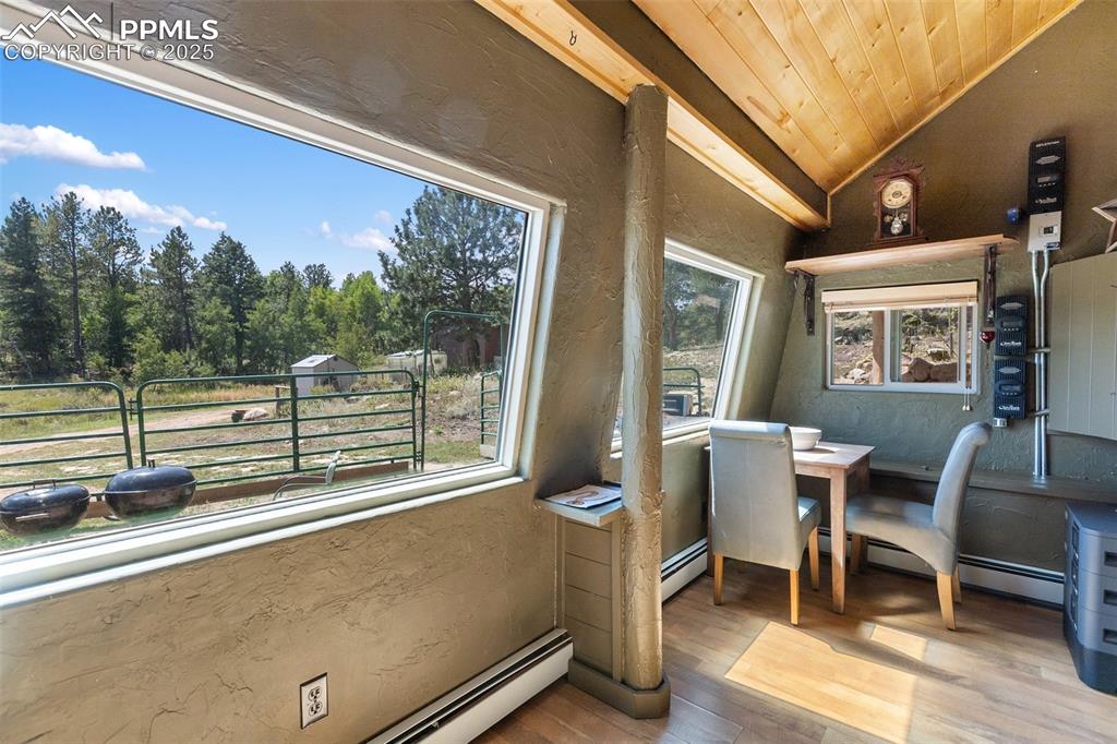 Image 25 of 50: Sunroom doubles as a breakfast nook with beautiful forest views.