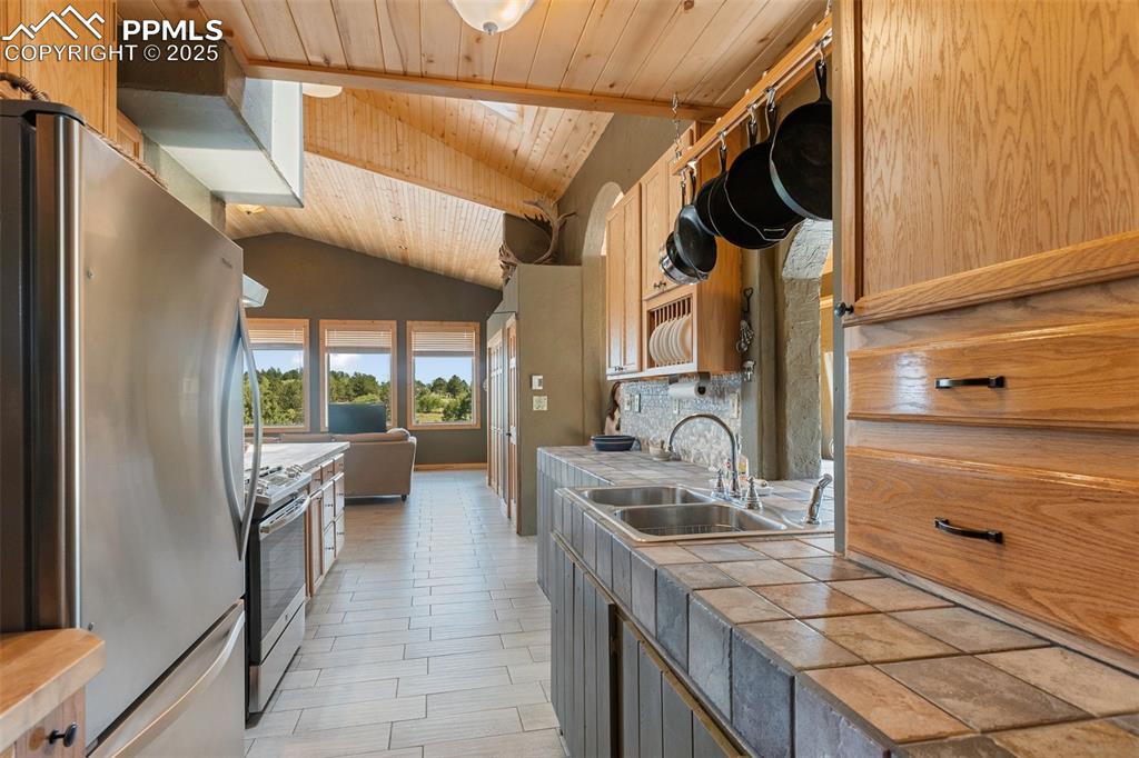 Image 9 of 34: Tiled countertops and stainless steel appliances.
