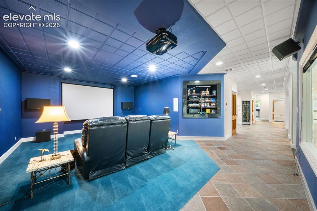 Image 30 of 50: Dedicated media room with projector and screen, recessed lighting, blue car