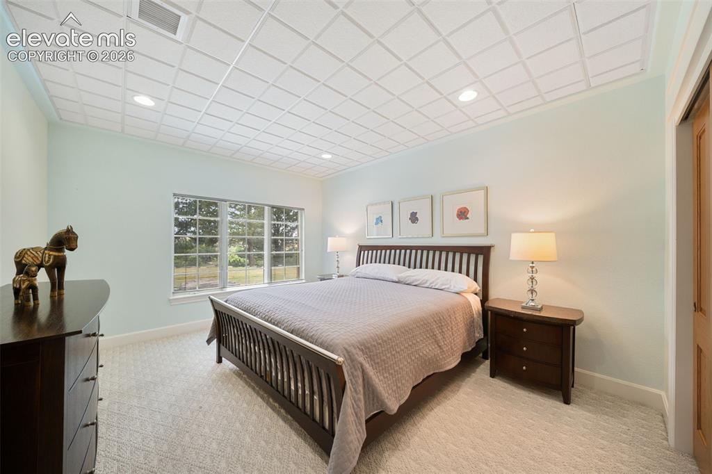 Image 31 of 50: Recessed lighting, light-colored walls, carpeted flooring, large window, an