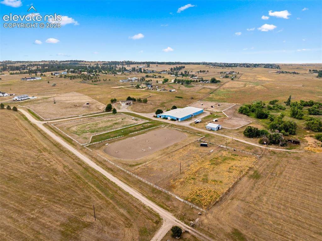 Image 47 of 50: Expansive rural property featuring an equestrian arena, multiple outbuildin
