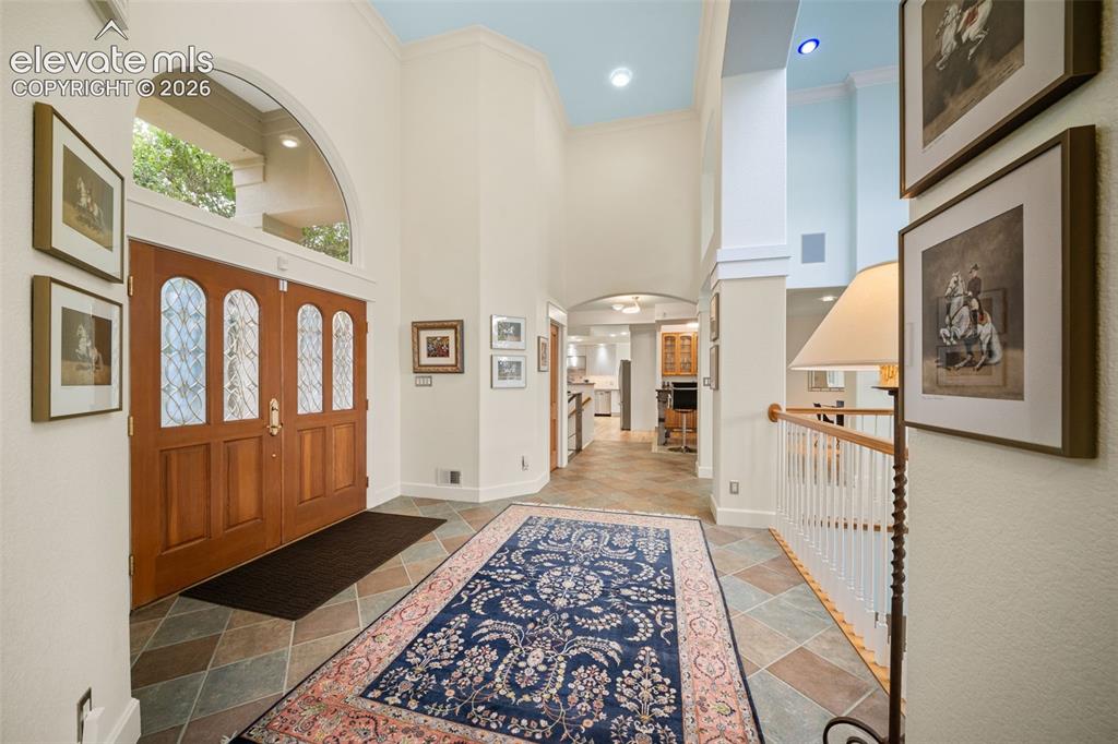Image 5 of 50: Double wood entry doors with leaded glass inserts, arched transom window, s